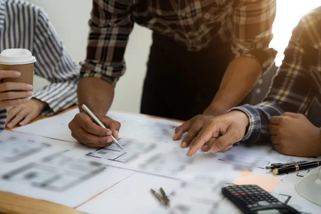 Courtier analysant des courbes de taux et un plan de financement avec ses clients lors d'un rendez-vous à Elven