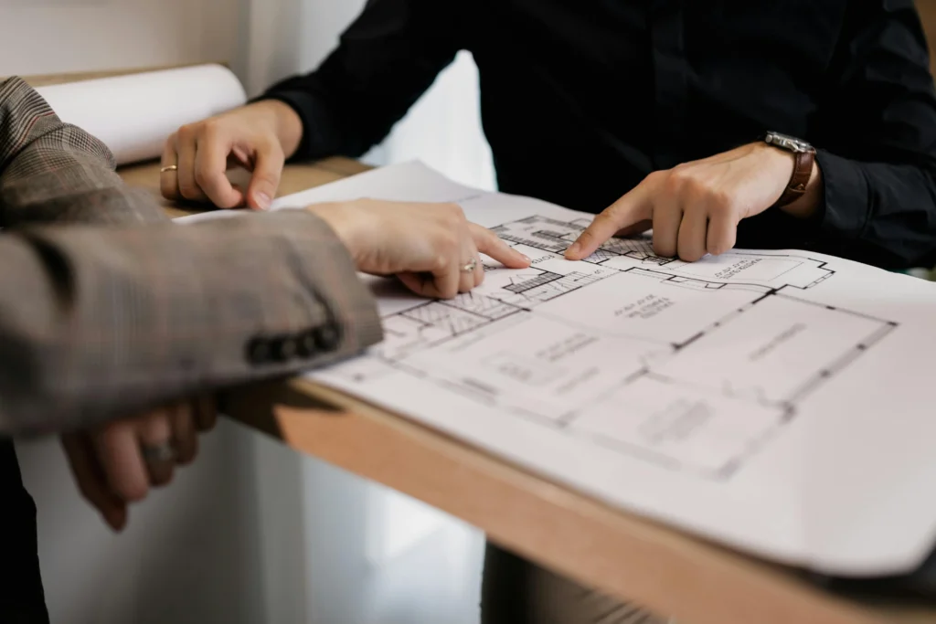 courtier à Janzé étudiant les plans d'une future maison pour valider le financement de la construction