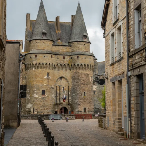 Vue d'une rue pavée menant au Château de Vitré, illustrant la proximité de votre courtier Vitré avec le marché immobilier du centre-ville